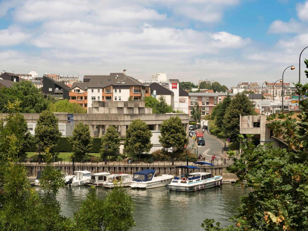 um grupo de barcos está ancorado num rio em ibis Nogent Sur Marne em Nogent-sur-Marne