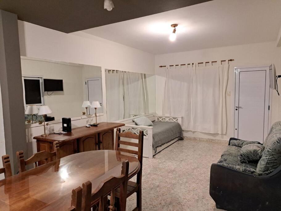 uma sala de estar com uma mesa e um sofá em Familiar 10 camas 3 hab 1,5 baños, excelente em Paraná
