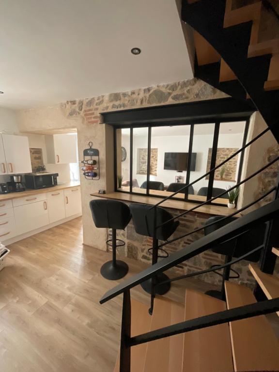 a living room with a staircase and a kitchen at Maison atypique centre bourg 15kms du PDF et Parc Maulévrier in Mauléon