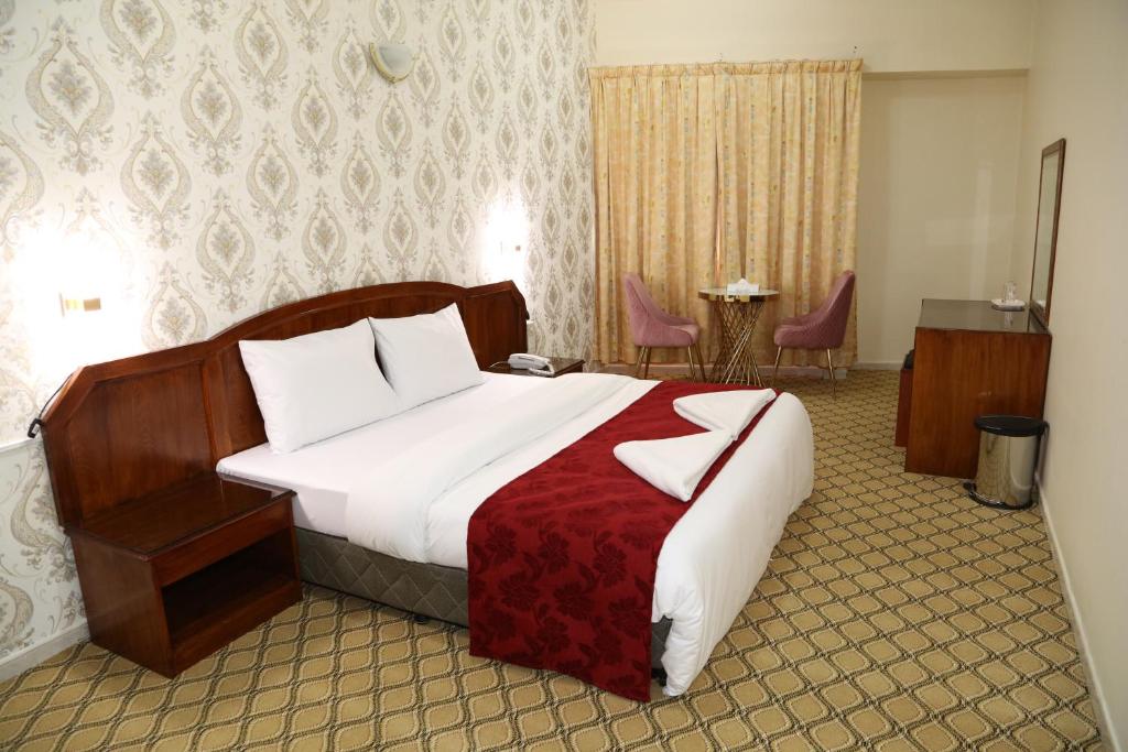 ein Schlafzimmer mit einem großen Bett mit einer roten Decke in der Unterkunft Sky Iconic in Dubai