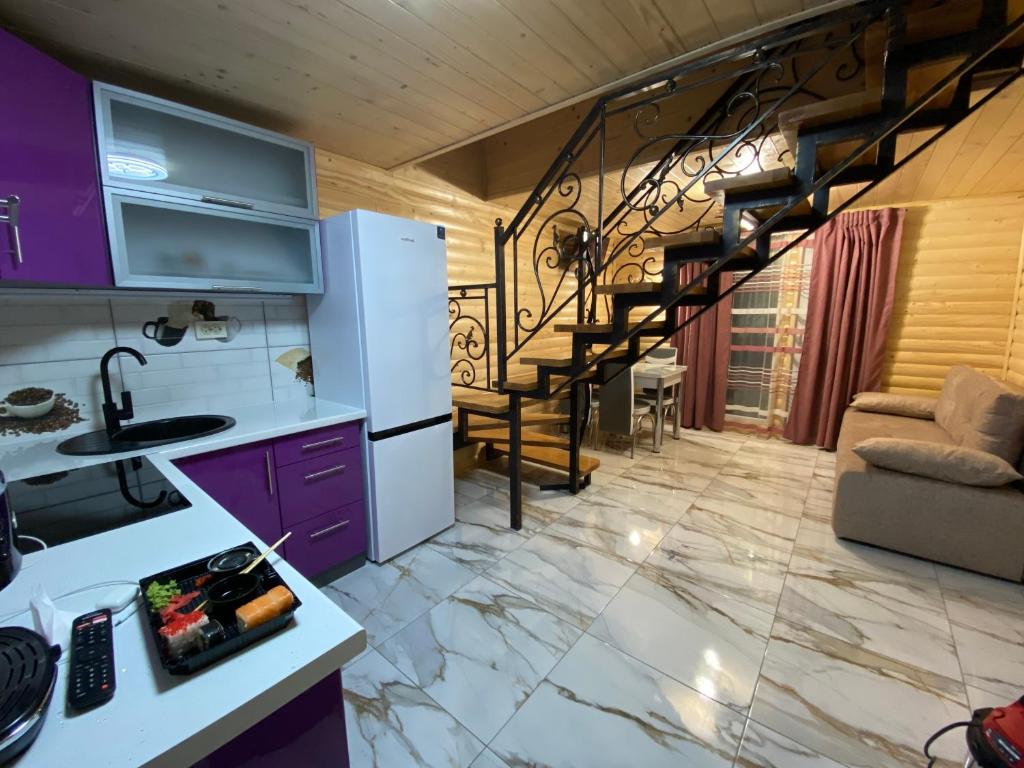 een keuken met paarse kasten en een wenteltrap bij Vienna House in Jaremtsje