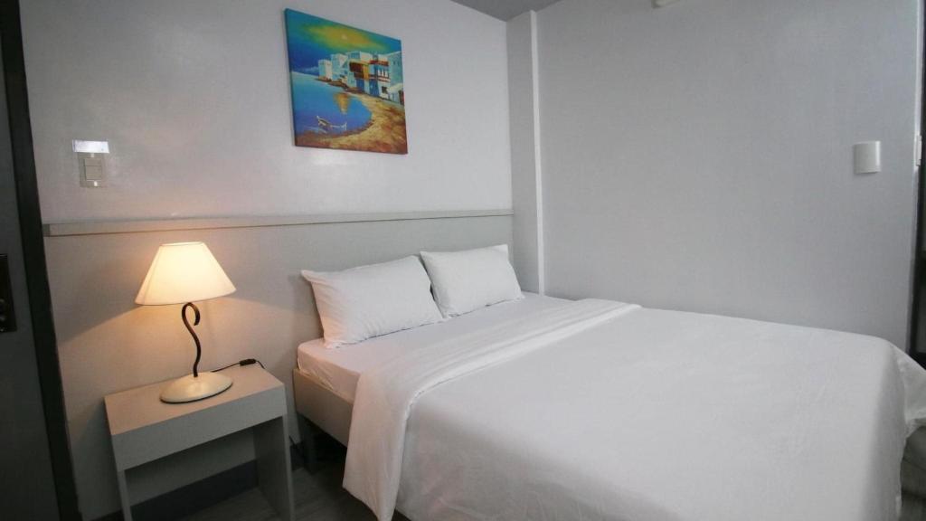Postel nebo postele na pokoji v ubytování SANDS Hotel Nasugbu