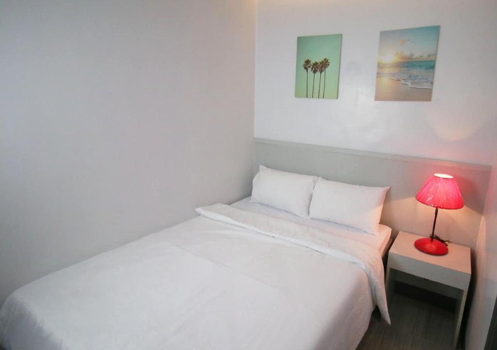 Postel nebo postele na pokoji v ubytování SANDS Hotel Nasugbu