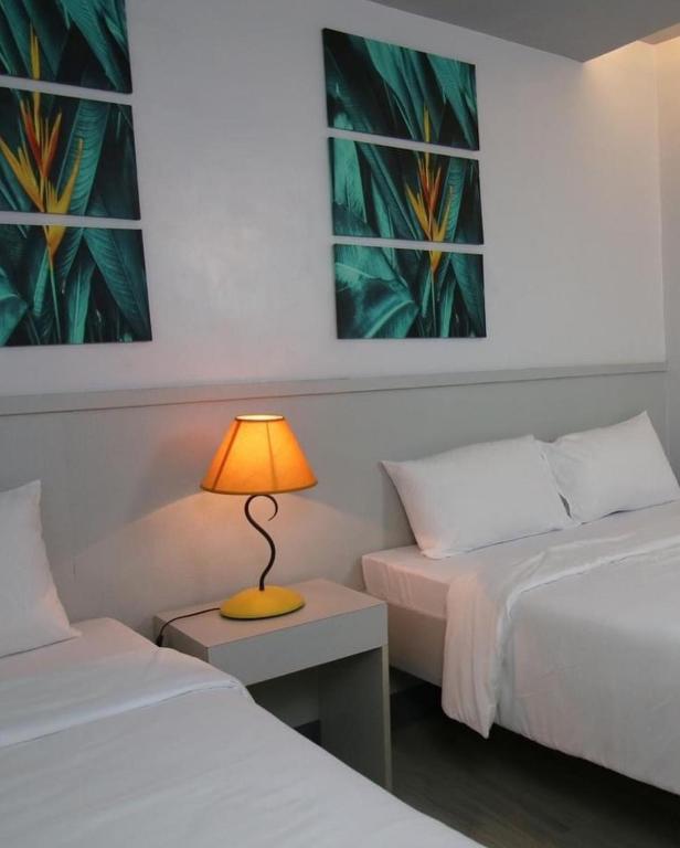 Postel nebo postele na pokoji v ubytování SANDS Hotel Nasugbu