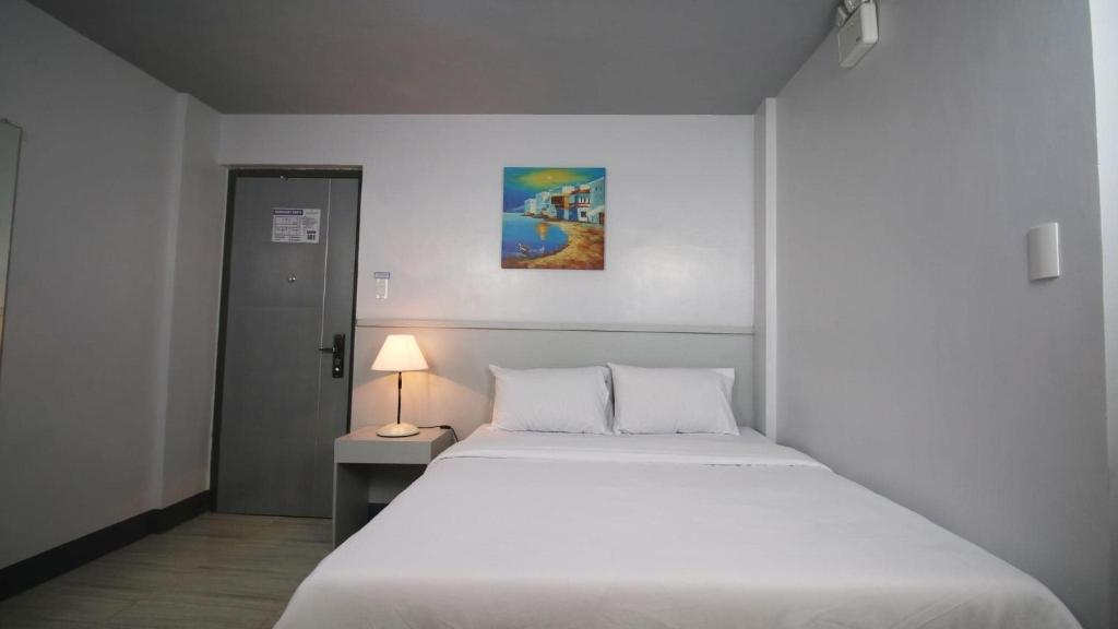 Postel nebo postele na pokoji v ubytování SANDS Hotel Nasugbu