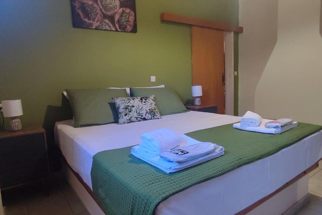 Olive Grove Cottage Skalani في Knossós: غرفة نوم عليها سرير وفوط