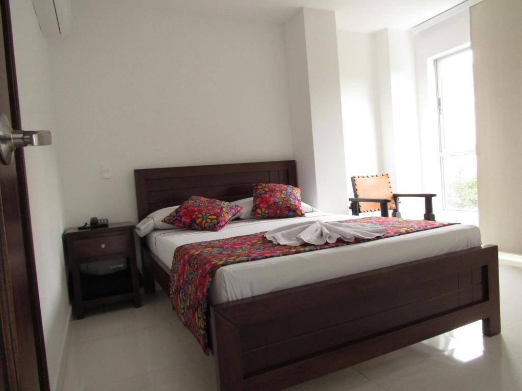 Habitación pequeña con cama y ventana en Hotel Plaza Berlín, en Medellín