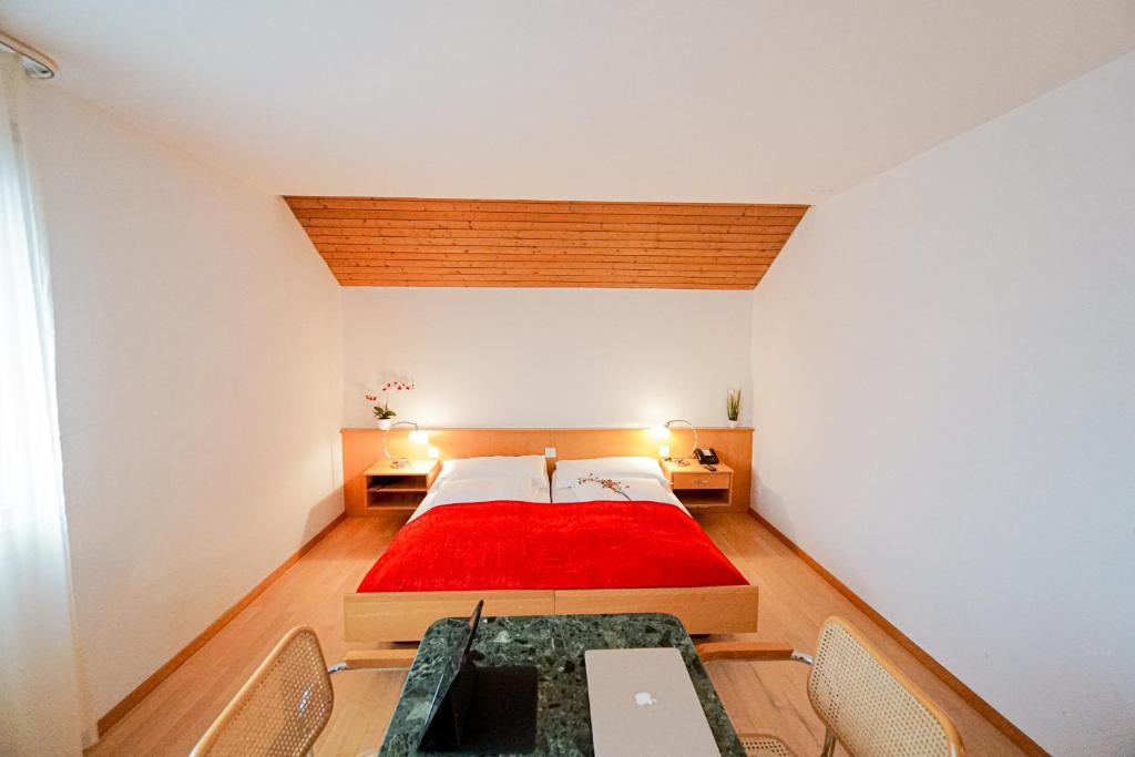 Centra Hotel Zurich في باسردورف: غرفة نوم بسرير كبير مع بطانية حمراء