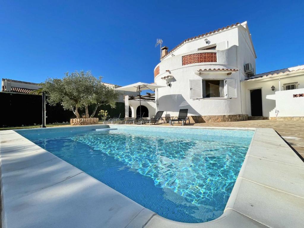 a swimming pool in front of a house at Villa Cabrera in L'Ampolla