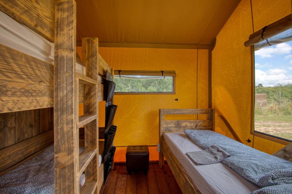 a bedroom with two bunk beds and a window at JOINS! Glamping Aquitaine in Saint Agne