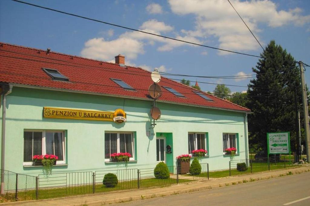 a green and white building with a red roof at Penzion u Balcarky in Ostrov u Macochy