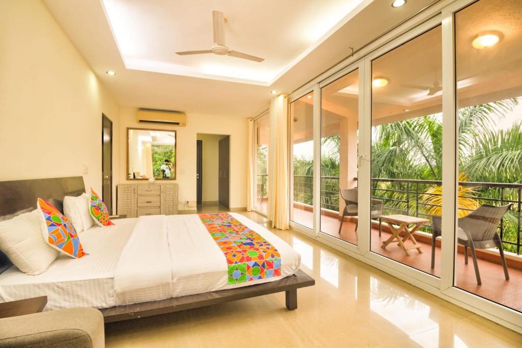 um quarto com uma cama e uma varanda em Luxury 3BHK Villa with Private Swimming Pool near Candolim em Marmagao