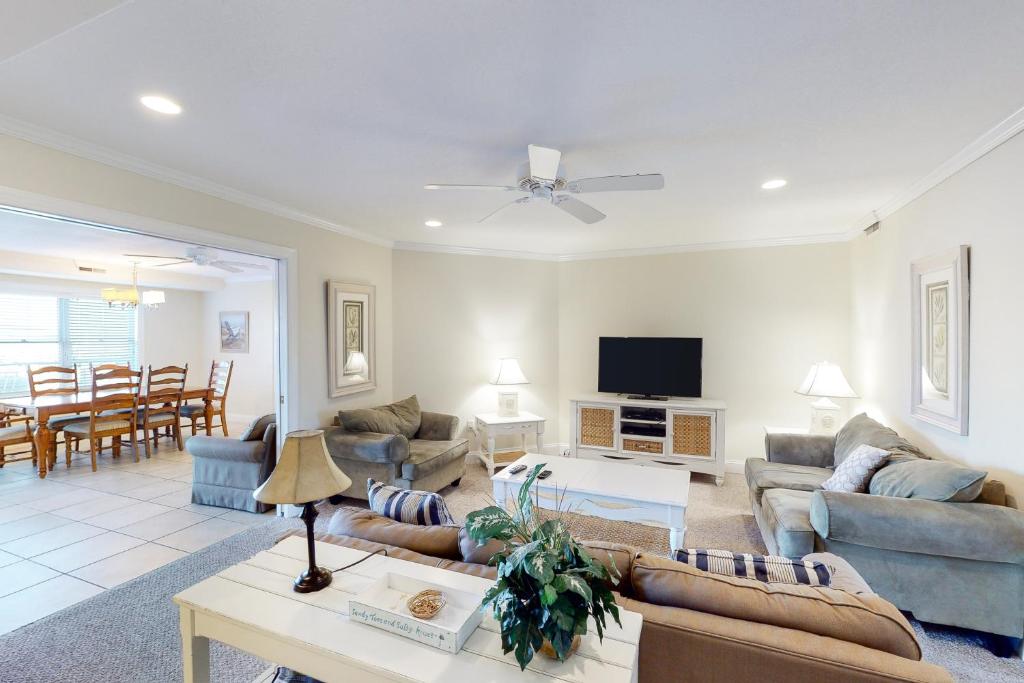 a living room with couches and a table and a tv at OC Condo 4100 #103 in Ocean City
