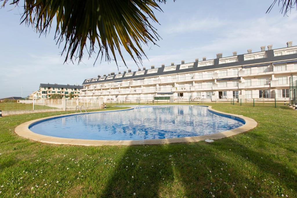 un edificio con una gran piscina en el césped en Apartagal-Océano V Barreiros, en Barreiros