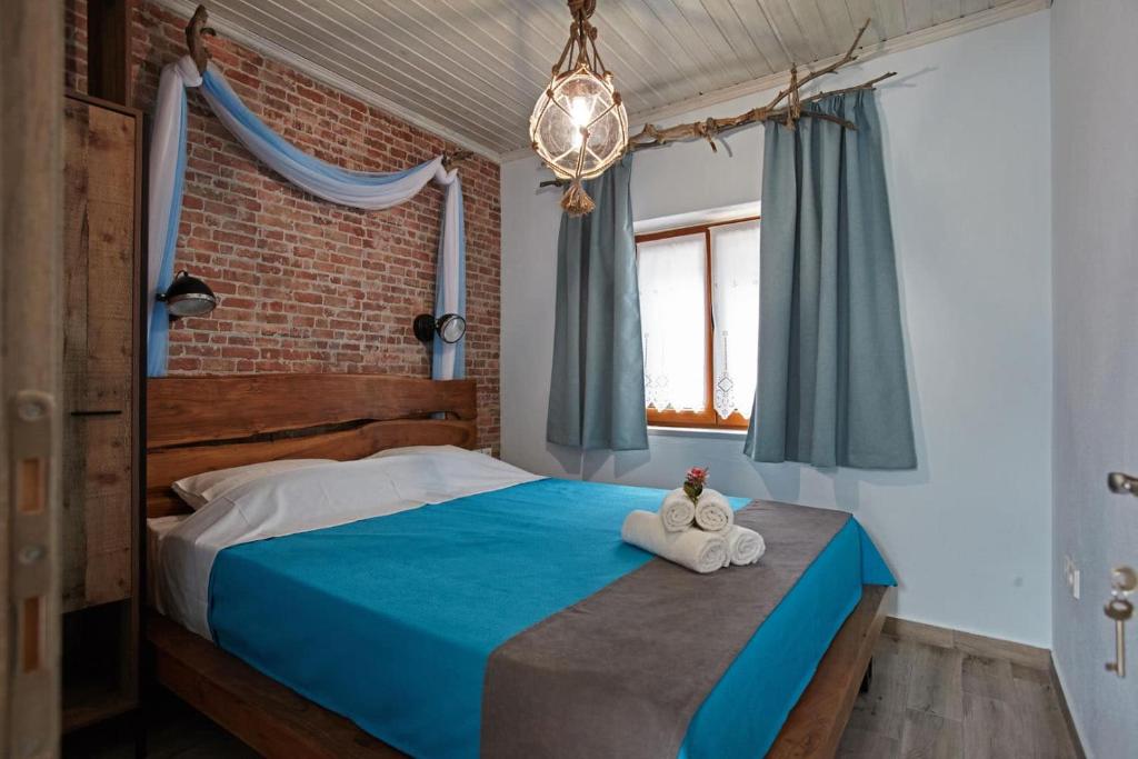 1 Schlafzimmer mit einem blauen Bett und 2 Handtüchern in der Unterkunft Kadmilos suites Samothraki in Samothráki