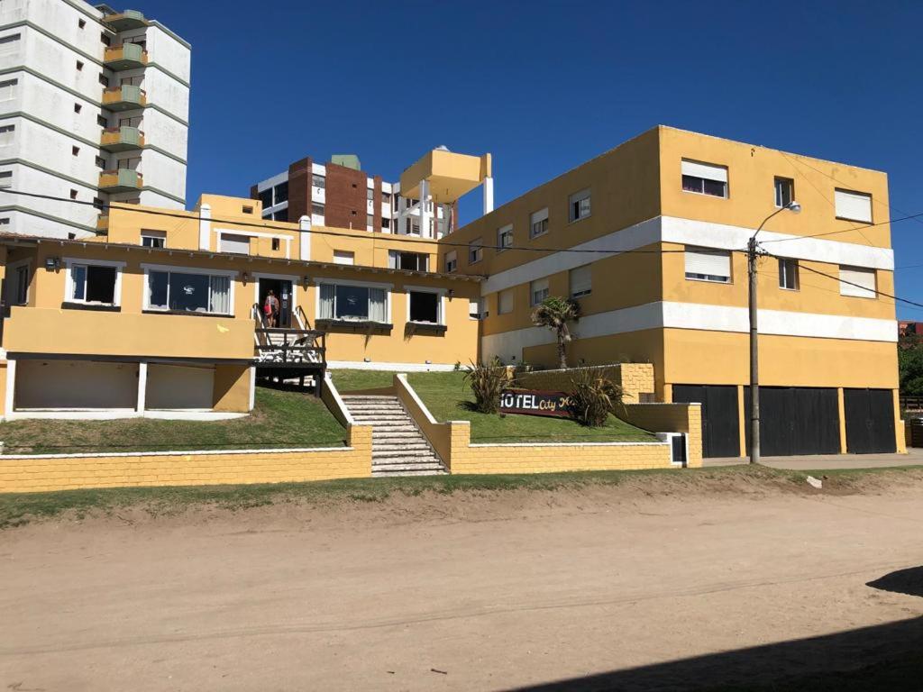 un edificio amarillo con escaleras frente a City mar playa en Villa Gesell