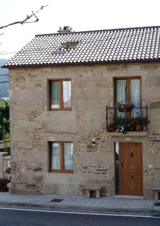 a stone building with a door and a window at Casa de Chica Ecoturismo in Lousame
