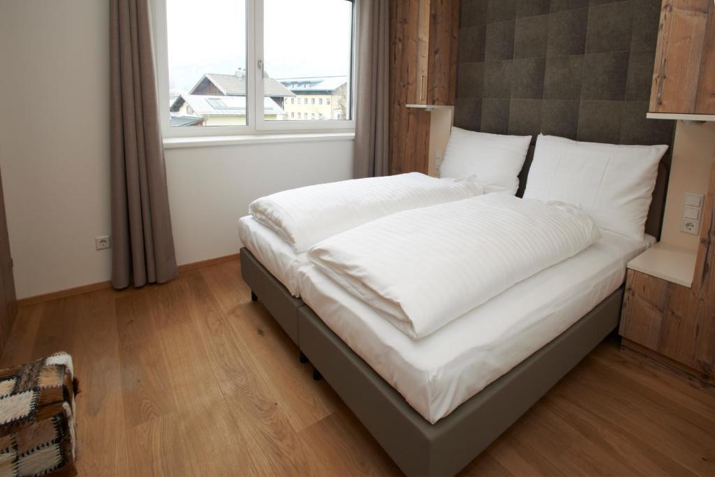 A bed or beds in a room at Ski & Golf Suites Zell am See by Alpin Rentals - incl Summercard