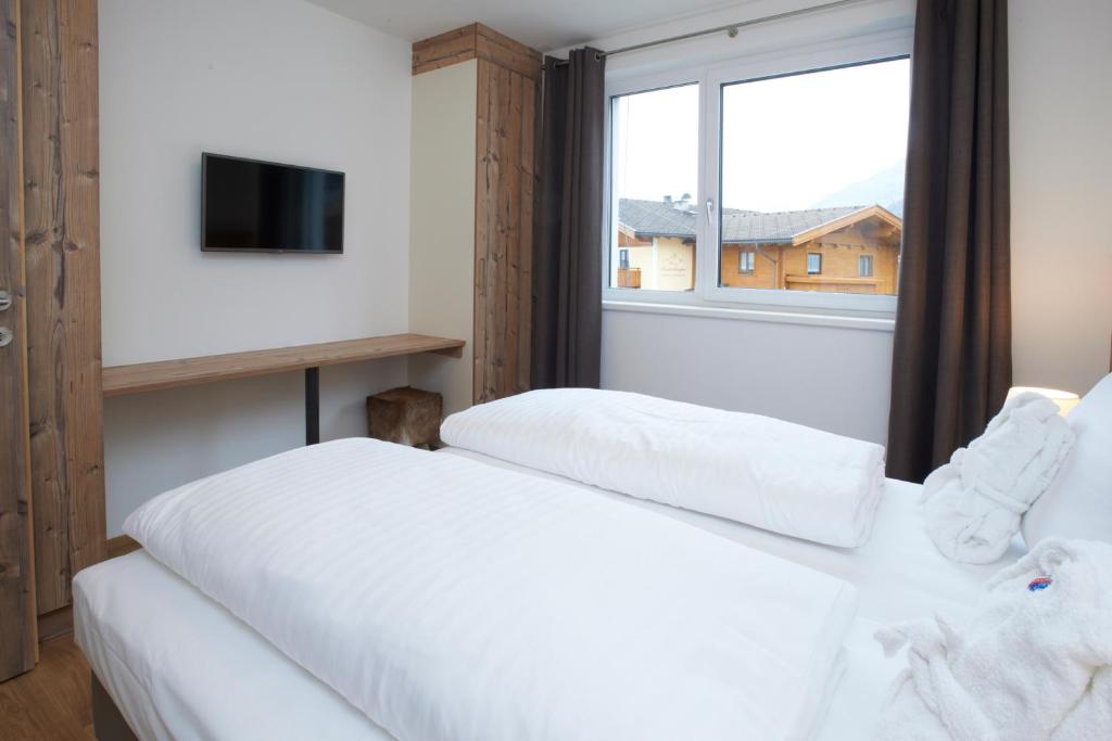 A bed or beds in a room at Ski & Golf Suites Zell am See by Alpin Rentals - incl Summercard