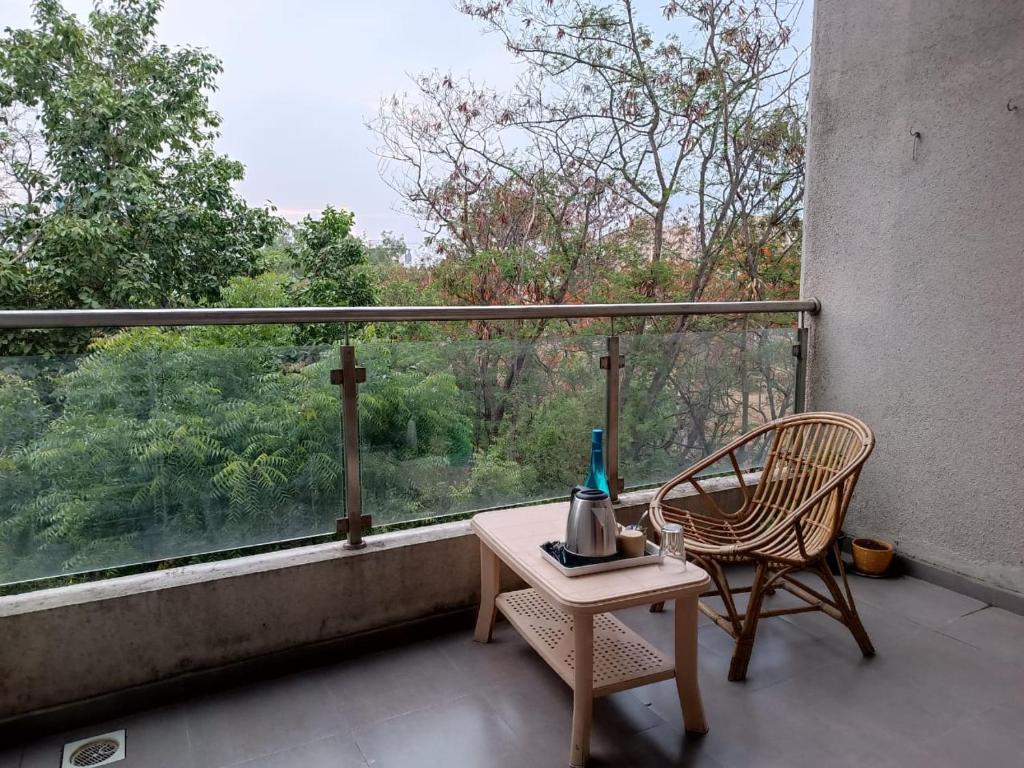 a balcony with a table and a chair and a window at Happy Stay Near Airport Pune in Pune