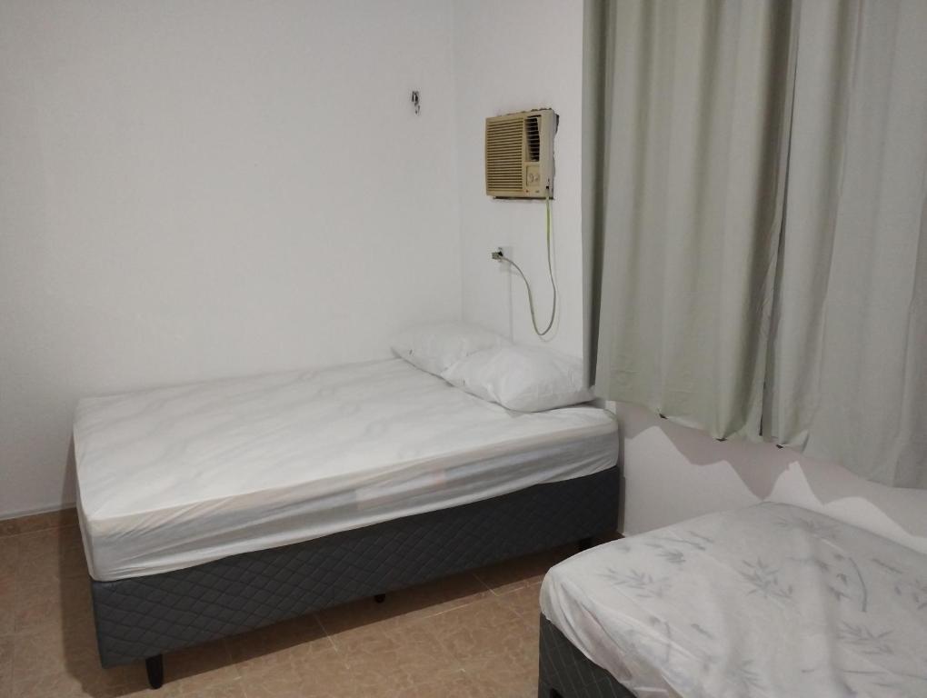 Llit o llits en una habitació de PRAIA ENSEADA - WI-FI e AR CONDICIONADO