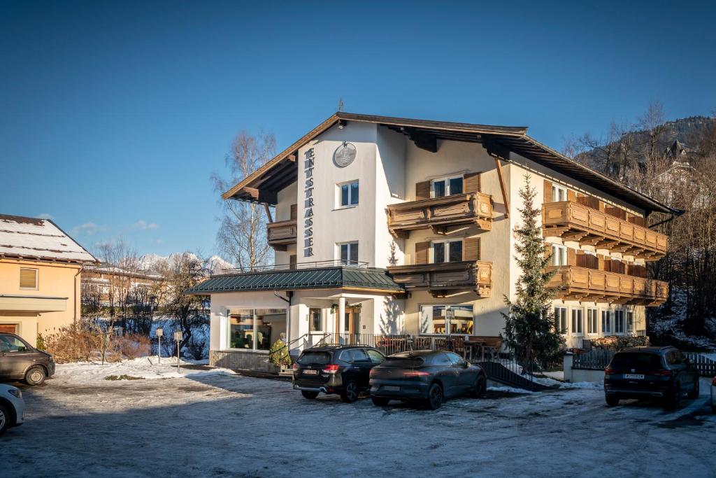 duży budynek z samochodami zaparkowanymi przed nim w obiekcie Hotel Garni Entstrasser w mieście Kitzbühel