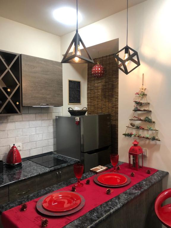 a kitchen with a table with red plates and a christmas tree at Karen's Dom & Terrace in Yerevan