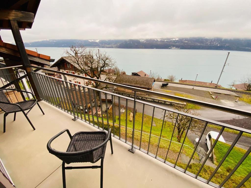 een balkon met 2 stoelen en uitzicht op het water bij Lake View Residence -16 in Niederried