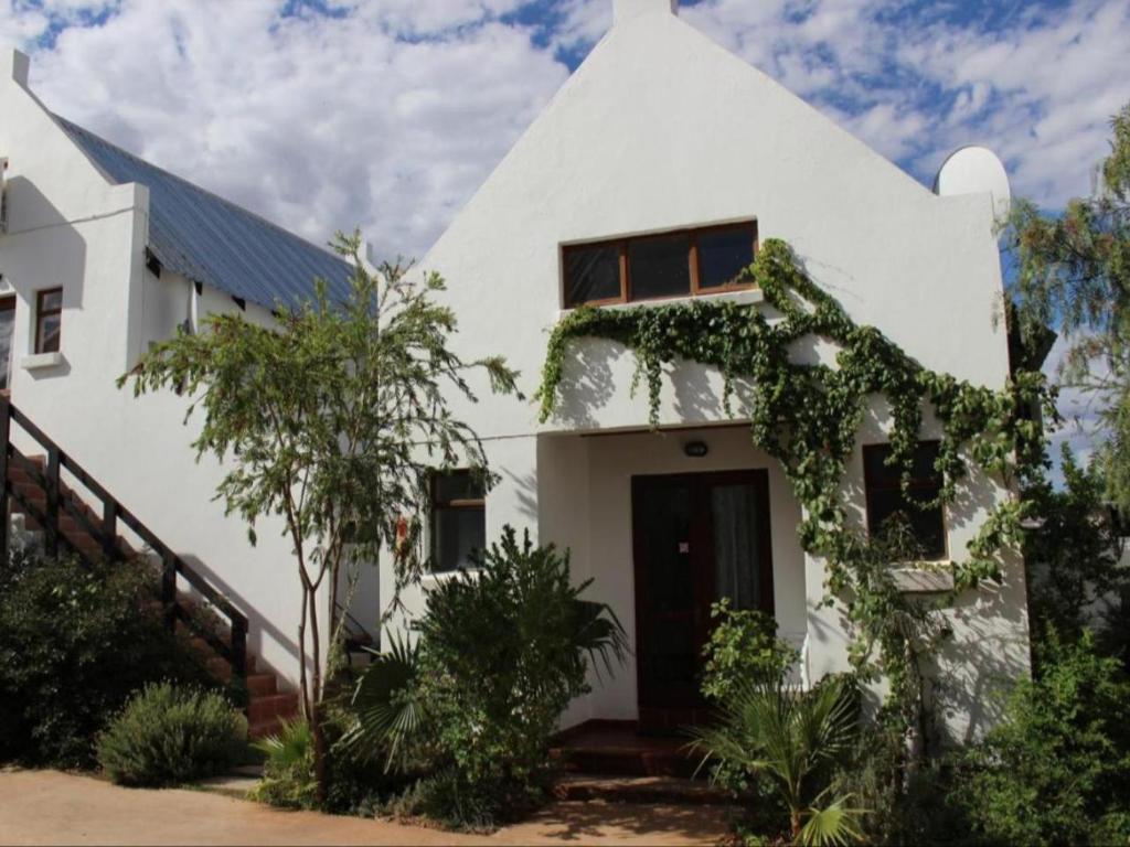 uma casa branca com hera a crescer nela em Geluksdam Guest House em Olifantshoek