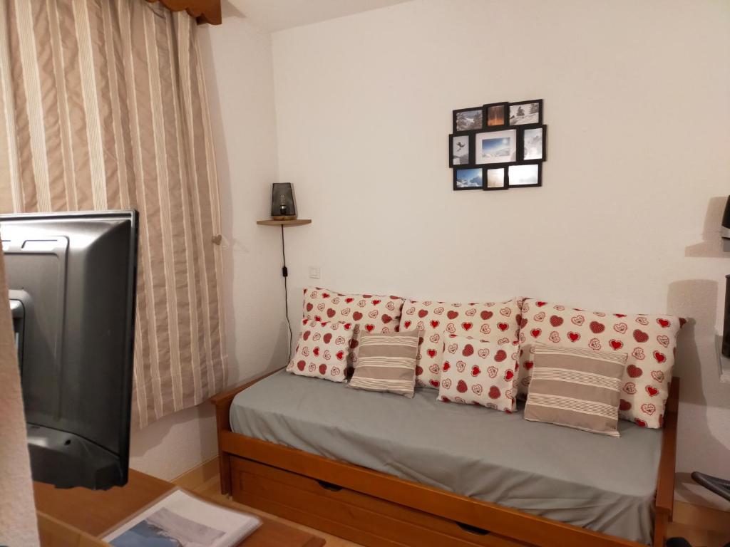 Habitación pequeña con sofá y TV. en Guzet Neige 1400 en Ustou