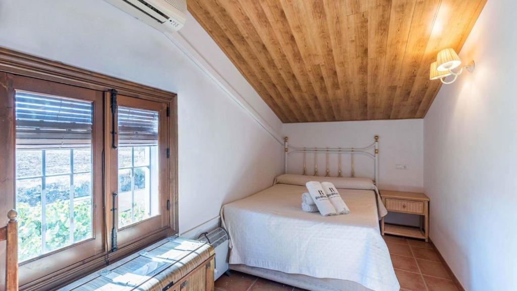 sypialnia z łóżkiem i dużym oknem w obiekcie Casa Rural Huertas del Rio Archidona by Ruralidays w mieście Archidona