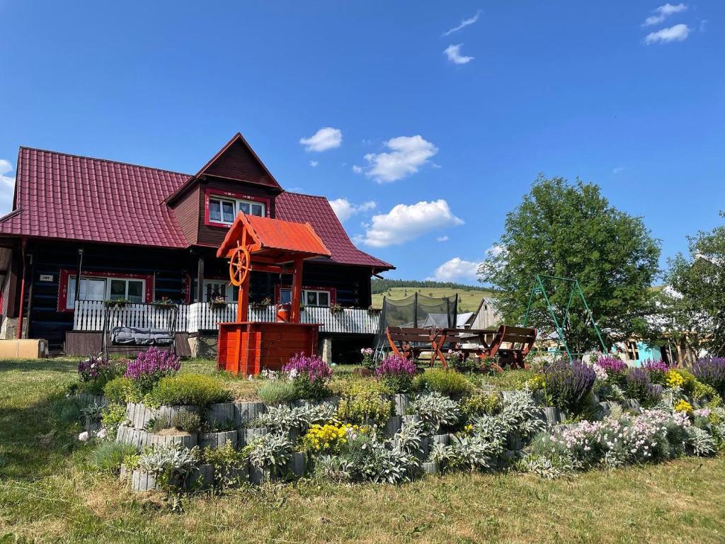 a house with a garden with flowers in the yard at Chalúpka v Ždiari in Ždiar