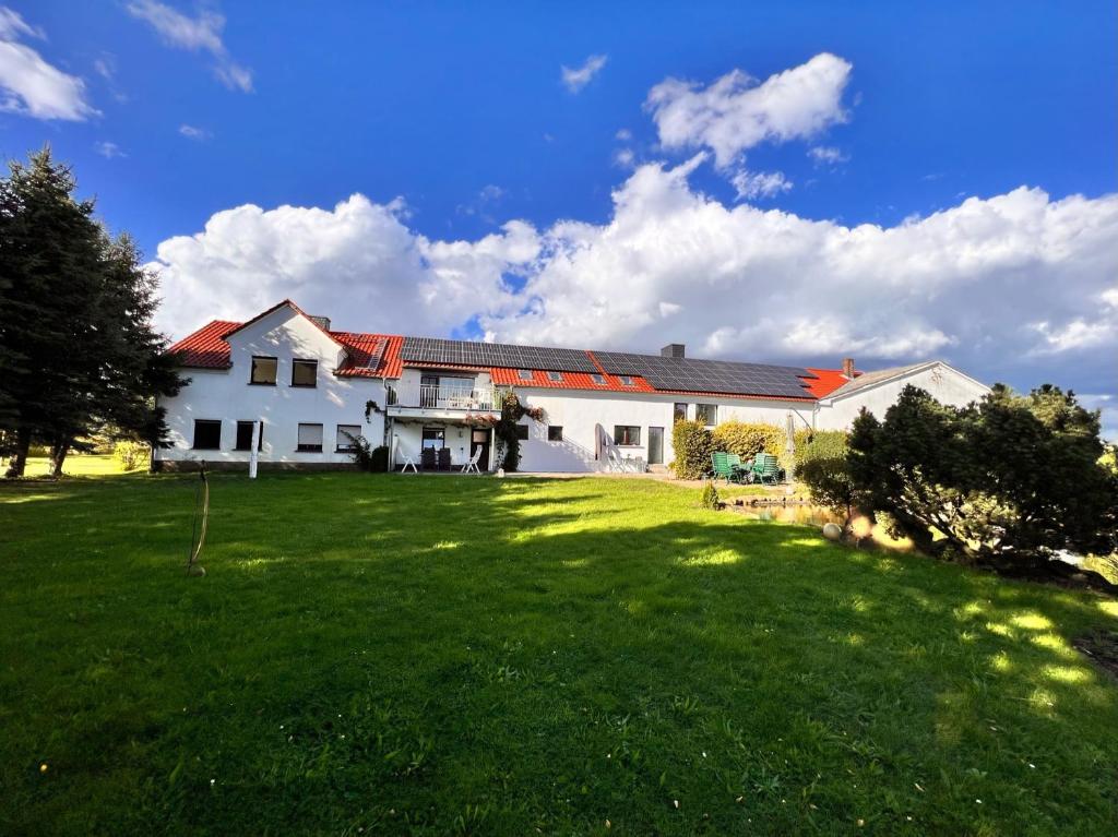 ein großes weißes Haus mit einem großen Hof in der Unterkunft ECOVILLA - Natur pur in Friedersdorf