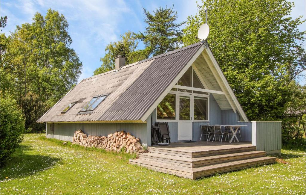 a small house with a roof with a deck at 2 Bedroom Pet Friendly Home In Samsø in Nordby