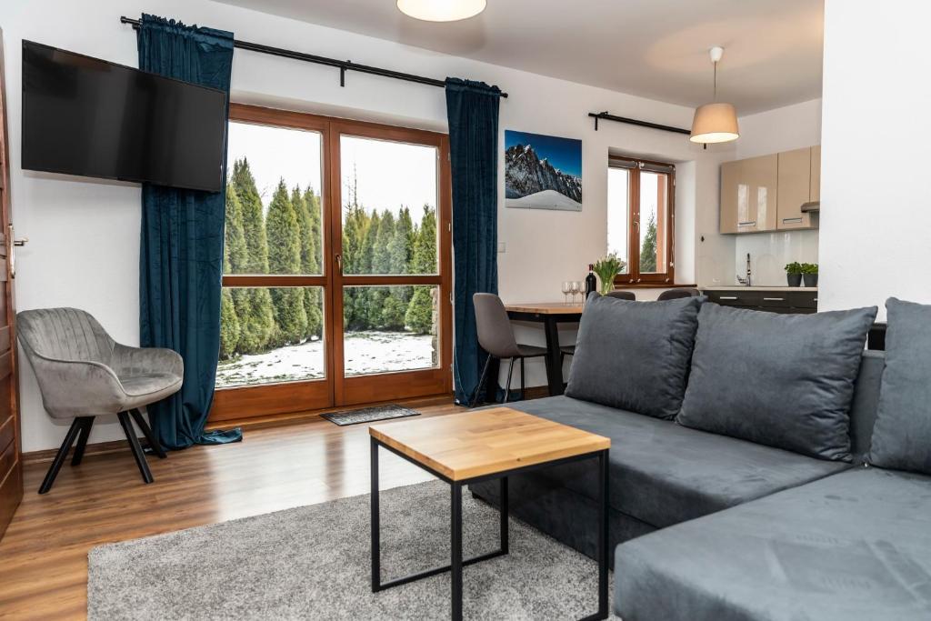 un soggiorno con divano e tavolo di udanypobyt Apartment Miętusia Dolina a Kościelisko