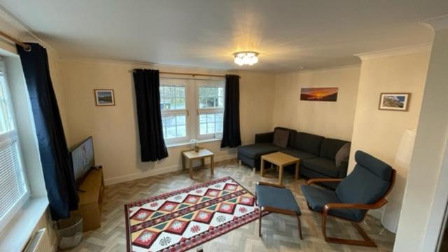 a living room with a couch and a tv at Peebles Cardona Cozy 2 x bedroom Apartment in Cardrona Mains