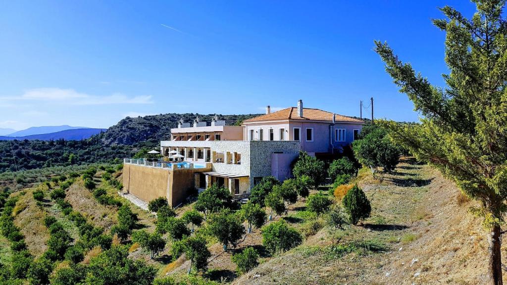 a house on the side of a hill with trees at Perivoli Country Hotel & Retreat in Nafplio