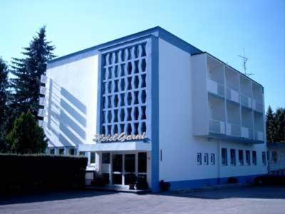 - un grand bâtiment blanc avec un panneau dans l'établissement Hotel Garni Trumm, à Dillingen an der Donau