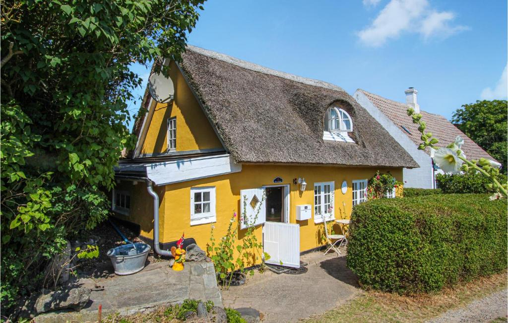 a yellow house with a thatched roof at 1 Bedroom Amazing Home In Sams in Brundby