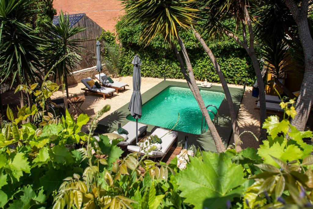 an overhead view of a pool with an umbrella and palm trees at Casa Con Destino-Adults Only in Jalón