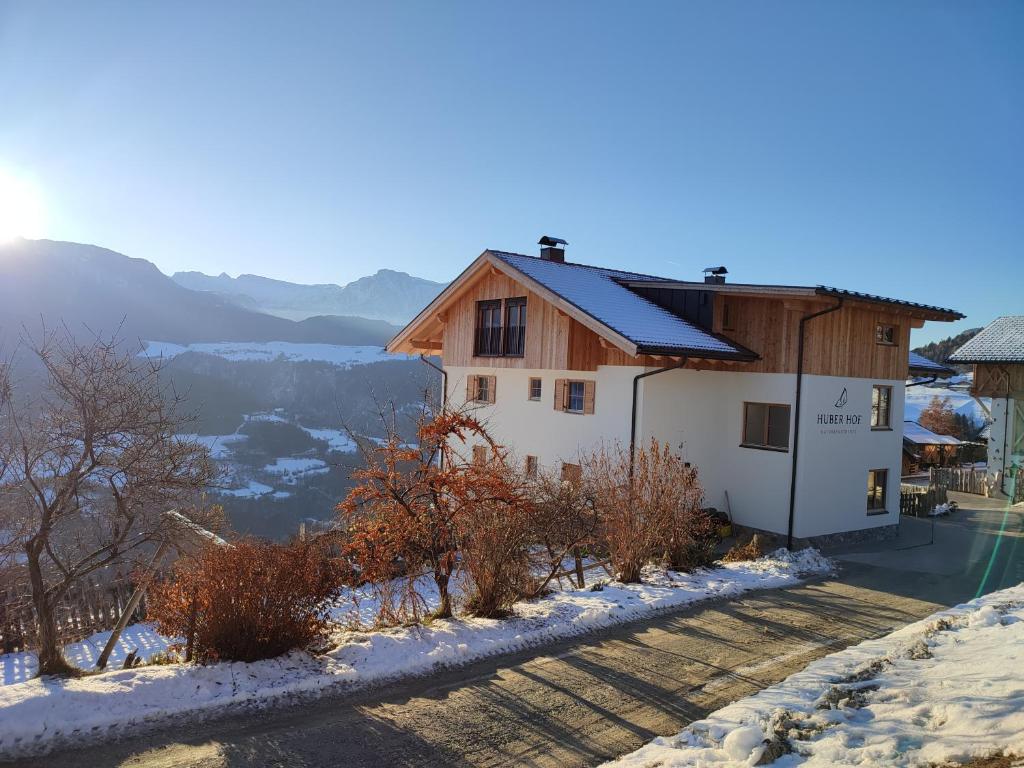 维兰德罗Huberhof的雪中山边的房子