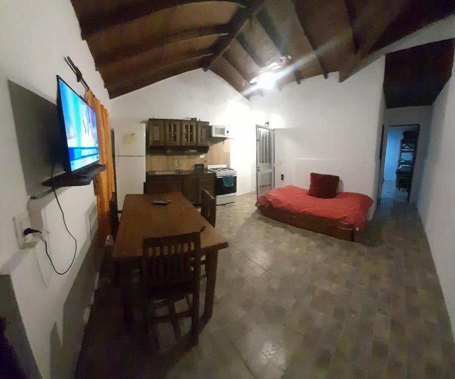 Habitación con cama, mesa y TV. en Alquiler Galo en Mar del Plata