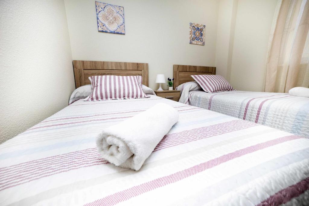 Duas camas com toalhas num quarto em Mesones parking gratis climatizado em Jaén
