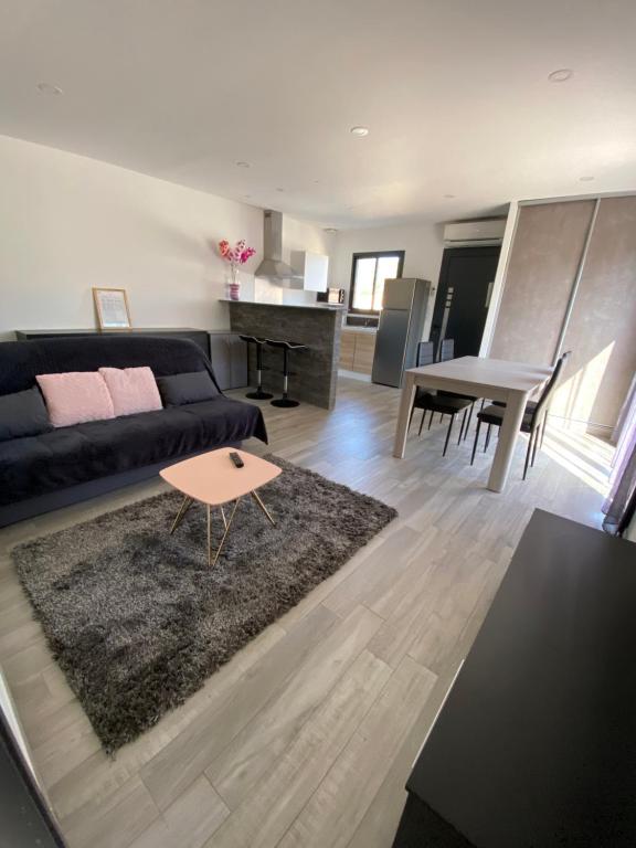 een woonkamer met een bank en een tafel bij Maison récente de 50 m2 pour 4 personnes in Porto-Vecchio