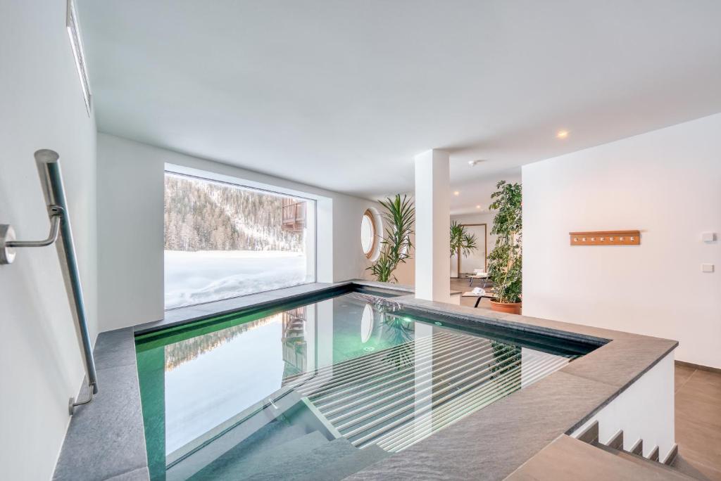 a swimming pool with a glass floor in a house at Hotel Cevedale in Solda