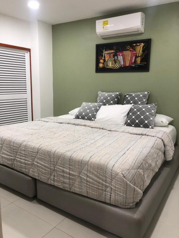 a bedroom with a bed with a air conditioner on the wall at Hermoso Apartamento de 2 alcobas in Cartagena de Indias