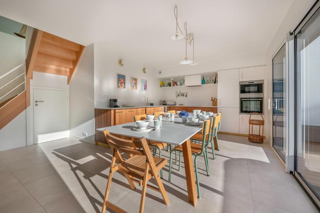 a dining room with a table and chairs in a kitchen at Lumineuse et accueillante maison pour 8 personnes in Sarzeau