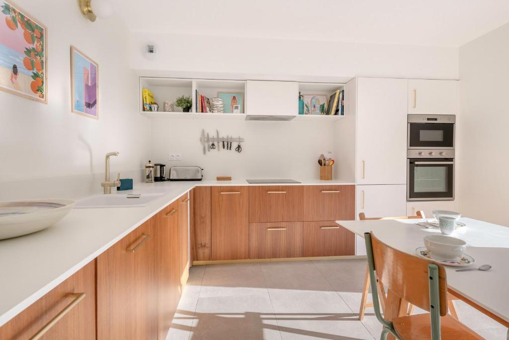 a kitchen with wooden cabinets and a white counter top at Lumineuse et accueillante maison pour 8 personnes in Sarzeau