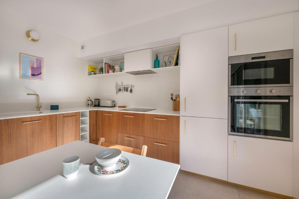 a kitchen with wooden cabinets and a white counter top at Lumineuse et accueillante maison pour 8 personnes in Sarzeau