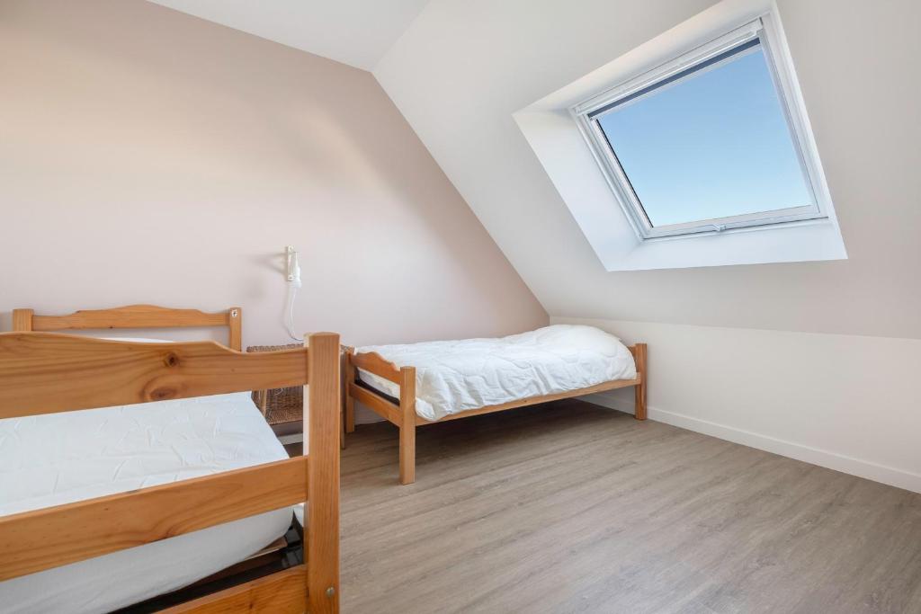 a bedroom with two bunk beds and a window at Lumineuse et accueillante maison pour 8 personnes in Sarzeau